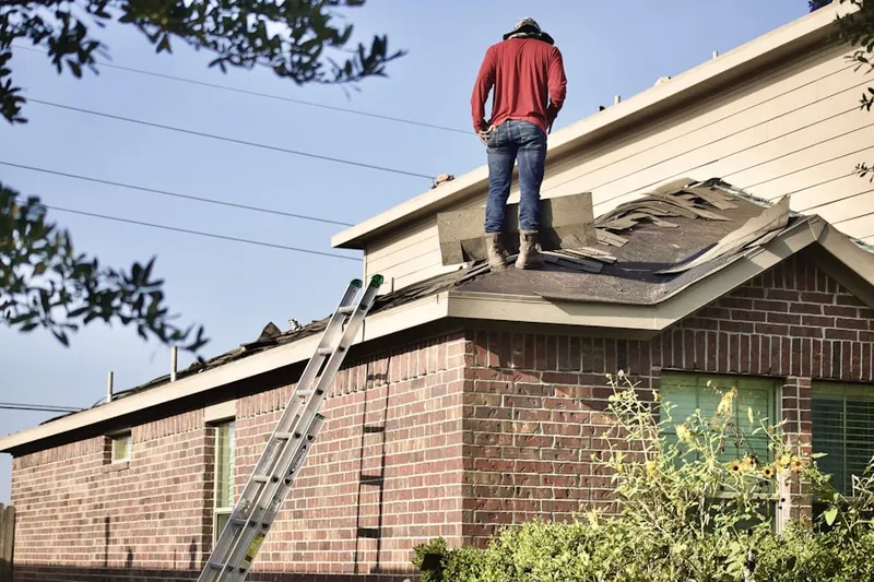 Professional roofer working on a residential roof in Penn North